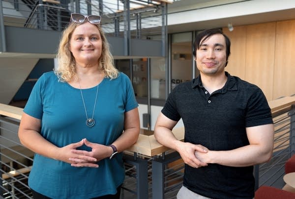 woman in blue shirt and man in black shirt standing
