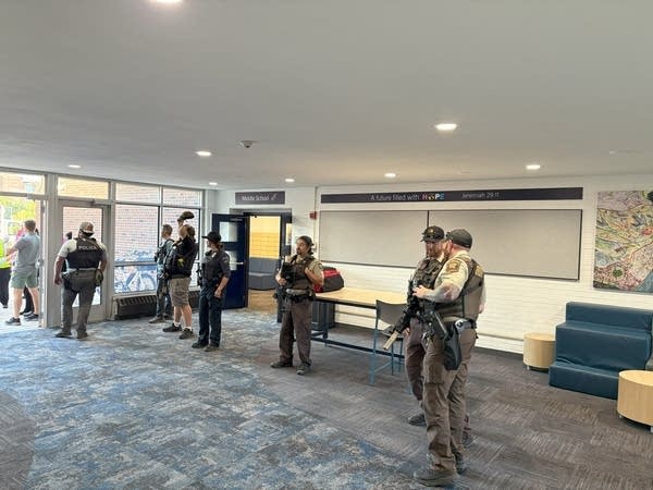 Firefighters and police walk through the halls of the church.