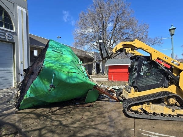A bulldozer next to a wooden pepper