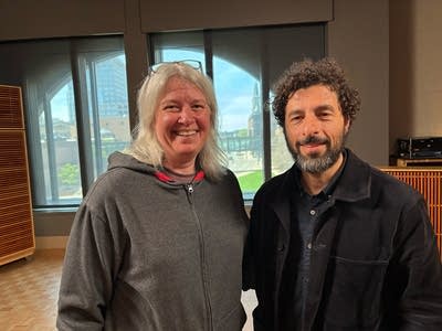 Two people stand together for a photo in a recording studio
