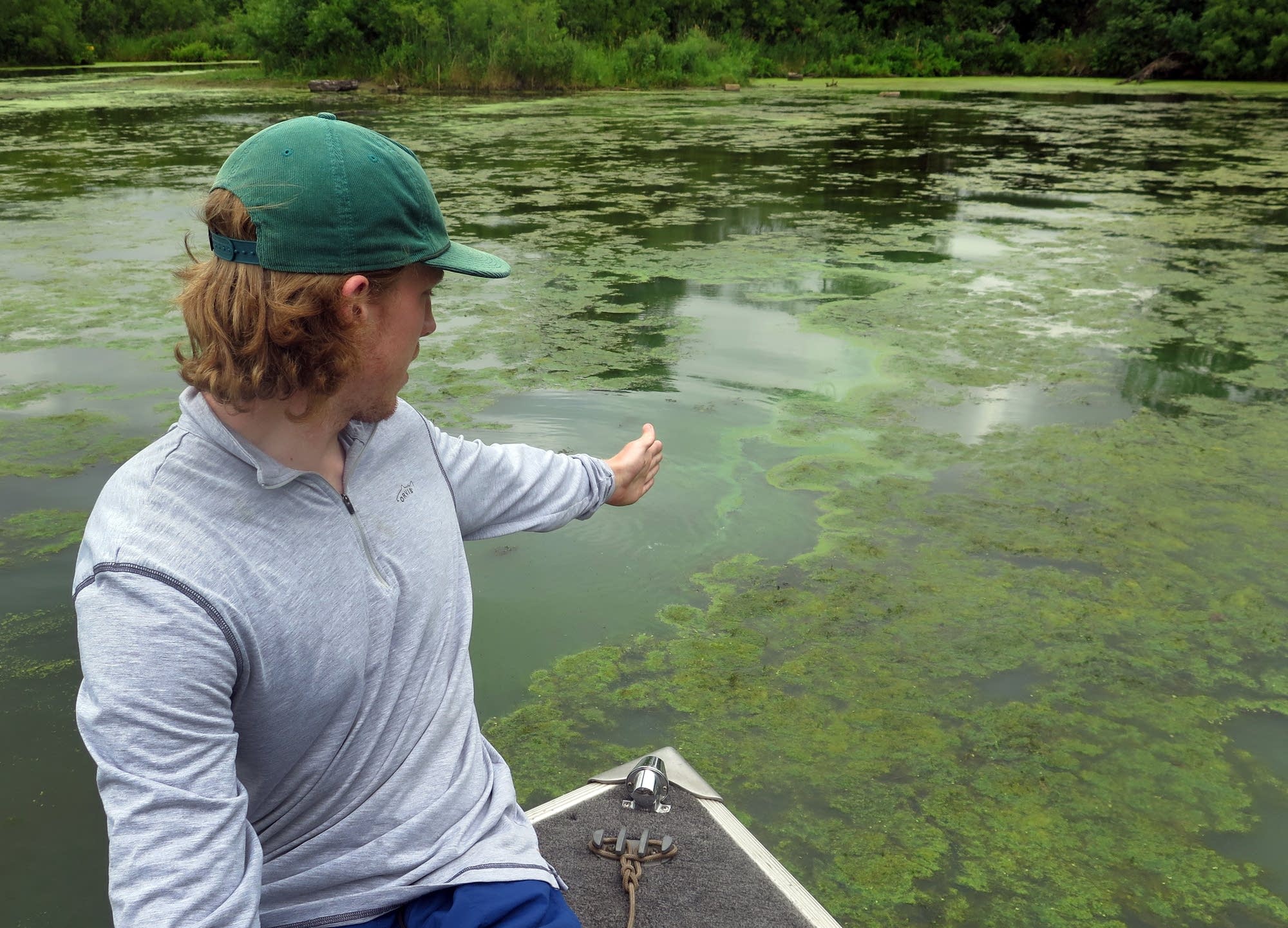 UMD graduate researcher Matt Bambach points at an algae bloom.