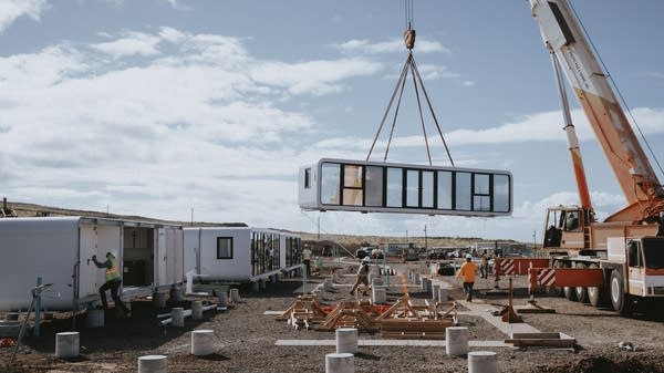 A crane lifts a prefab modular home.