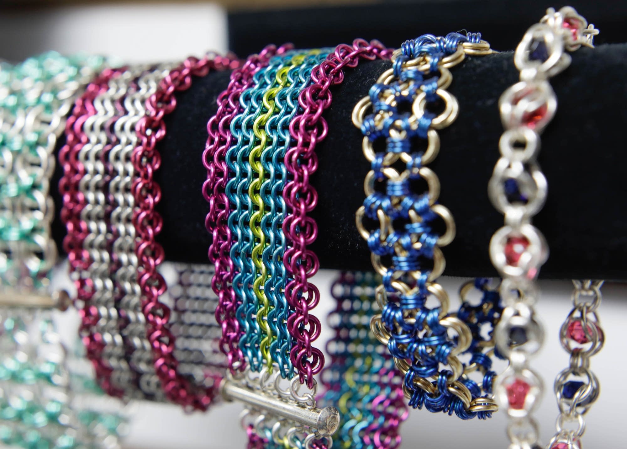 Colorful bracelets made with the chainmaille rings are displayed.