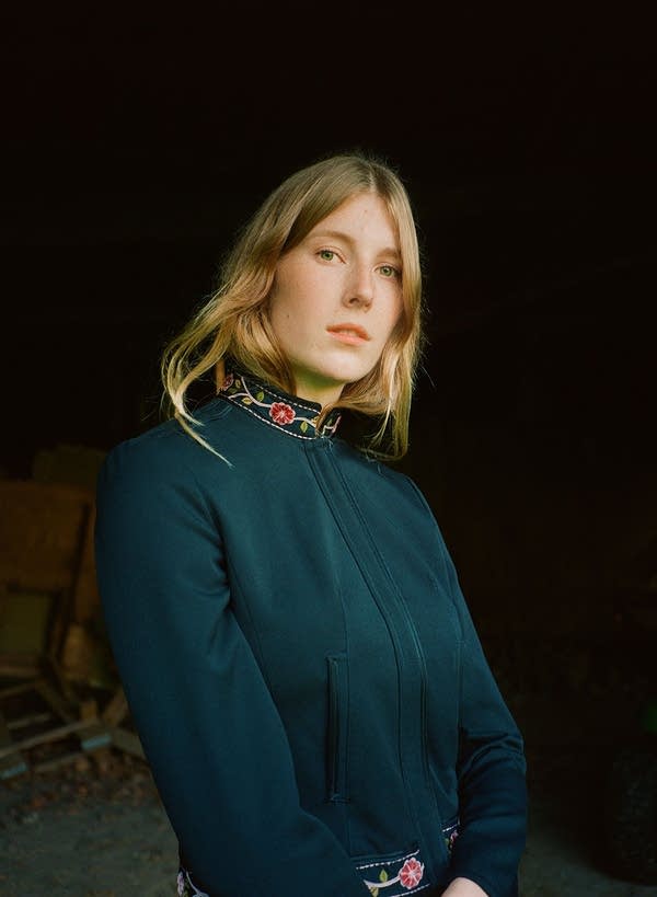 A woman in a cardigan poses for a portrait