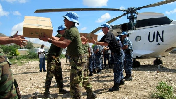Aid workers receives flood relief supplies in Gonaives, Haiti September 21, 2004.