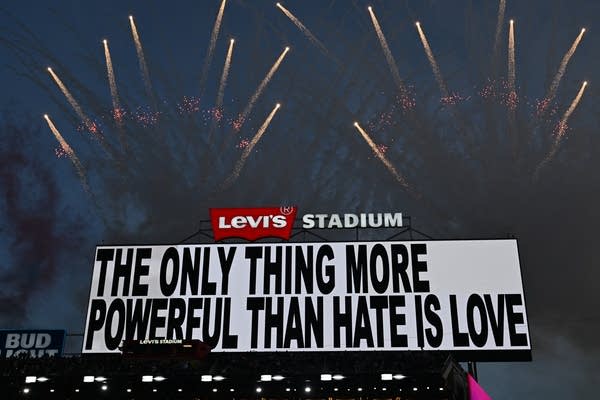 A sign says "The only thing more powerful than hate is love."