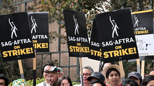 Strikers hold signs at a SAG-AFTRA picket line on Oct. 10, 2023. But the media landscape has changed since then as SAG-AFTRA now returns to the negotiating table.