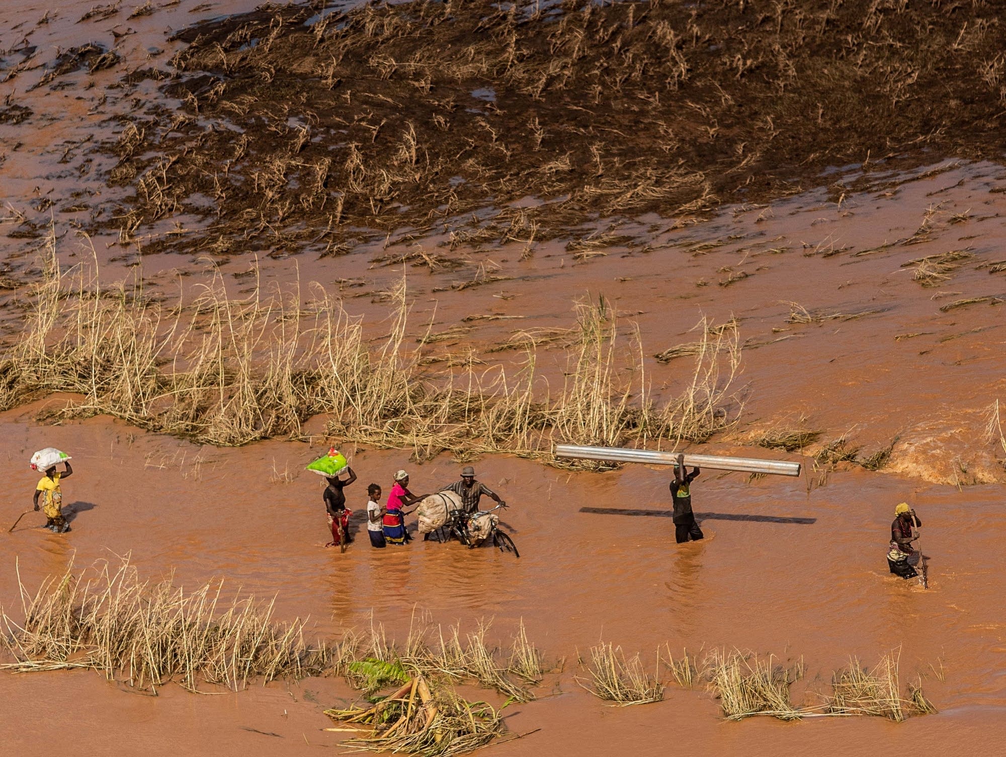 People wade through flood waters from Cyclone Idai