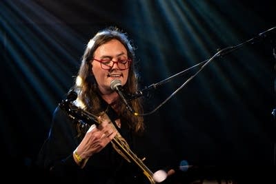 A musician performing onstage in a music venue