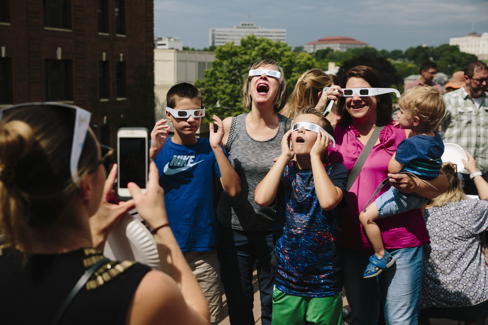 People pose for a photo while looking up at the eclipse.