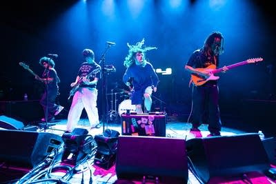 A band performing onstage in a large music venue