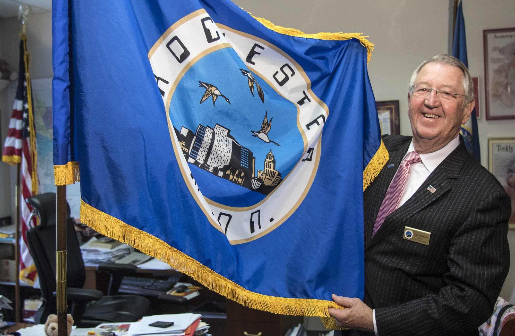Rochester mayor Ardell Brede displays the city flag in his office.