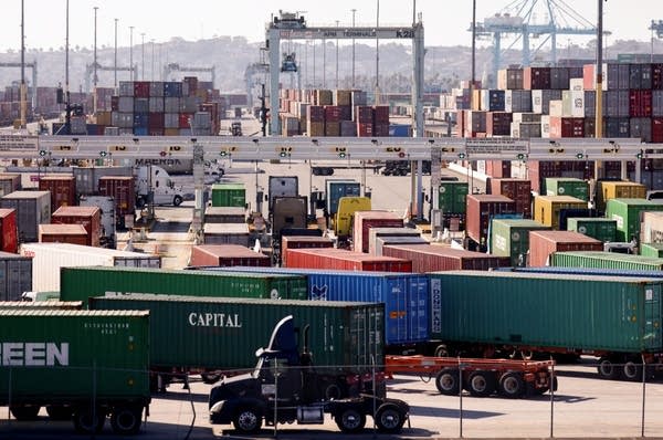 Trucks haul shipping containers at the Port of Los Angeles on November 24, 2021 in San Pedro, California. 