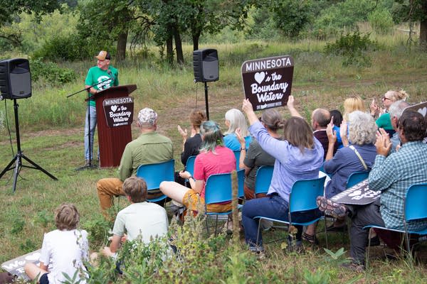 A man stands at a podium that reads "Minnesota Loves the Boundary Waters."