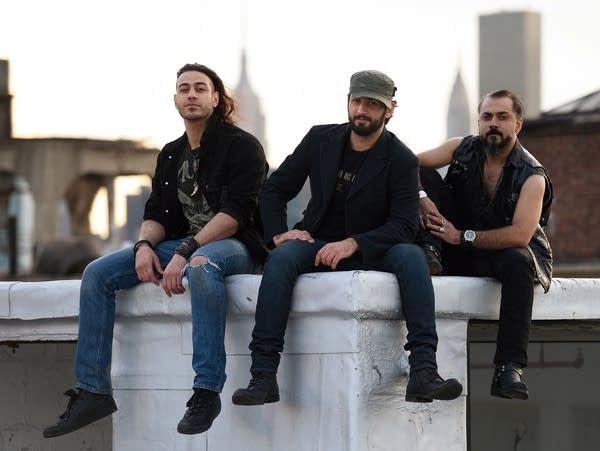 Members of the Iraqi heavy metal band Acrassicauda, (L to R) guitarist Moe Al Hamawandi, drummer and lyricist Marwan Hussein, and singer Faisal Mustafa, pose for a photo on the roof of Spin Recording Studios April 30, 2015 in New York.