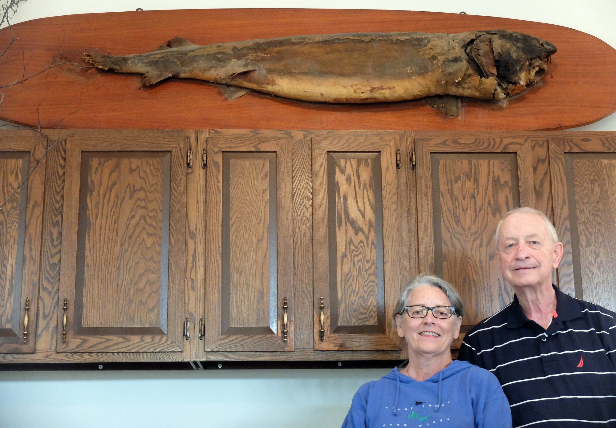 Karen and John Borg stand beneath the original mount of the 1948 sturgeon.