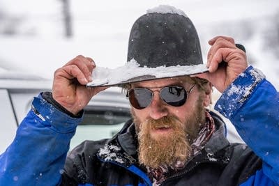 Jake Weber of Ice Dam Guys adjusts his hat before climbing to the roof.