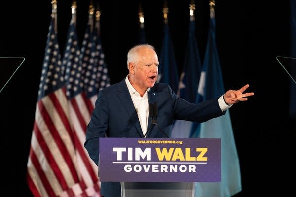 walz holding hand up speaking at podium
