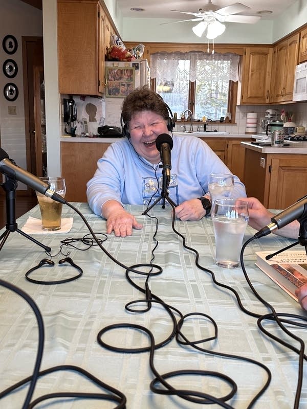 A woman smiles at a table