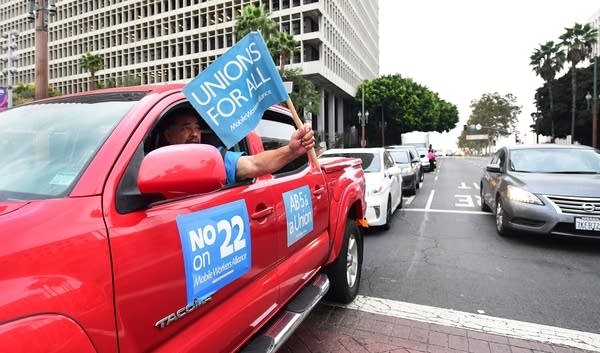 App-based drivers from Uber and Lyft protest in a caravan in front of City Hall in Los Angeles on October 22, 2020.