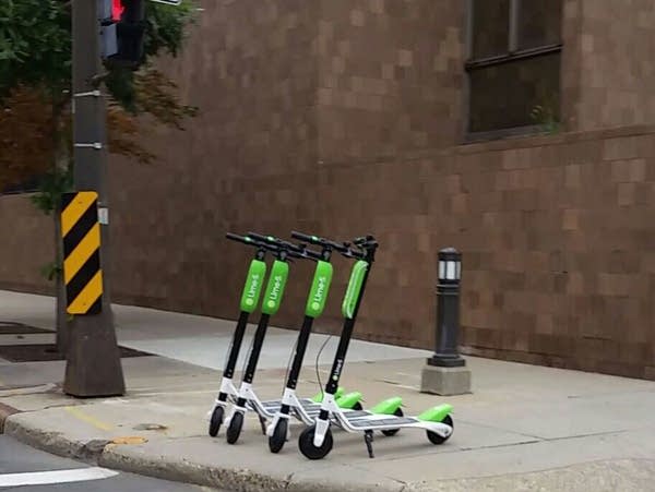 Lime scooters wait at an intersection in St. Paul.