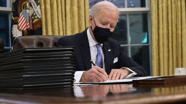 President Joe Biden prepares to sign a series of executive orders at the Resolute Desk in the Oval Office just hours after his inauguration on Jan. 20, 2021 in Washington.