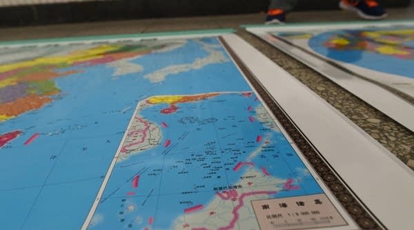 A map of China which includes an insert with red dotted lines showing China's claimed territory in the South China Sea.