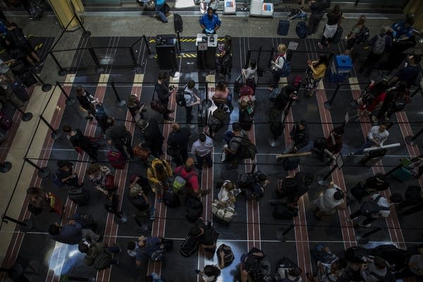 Travelers wait in line to go through a security checkpoint at Reagan National Airport in Arlington, Virginia, in May.