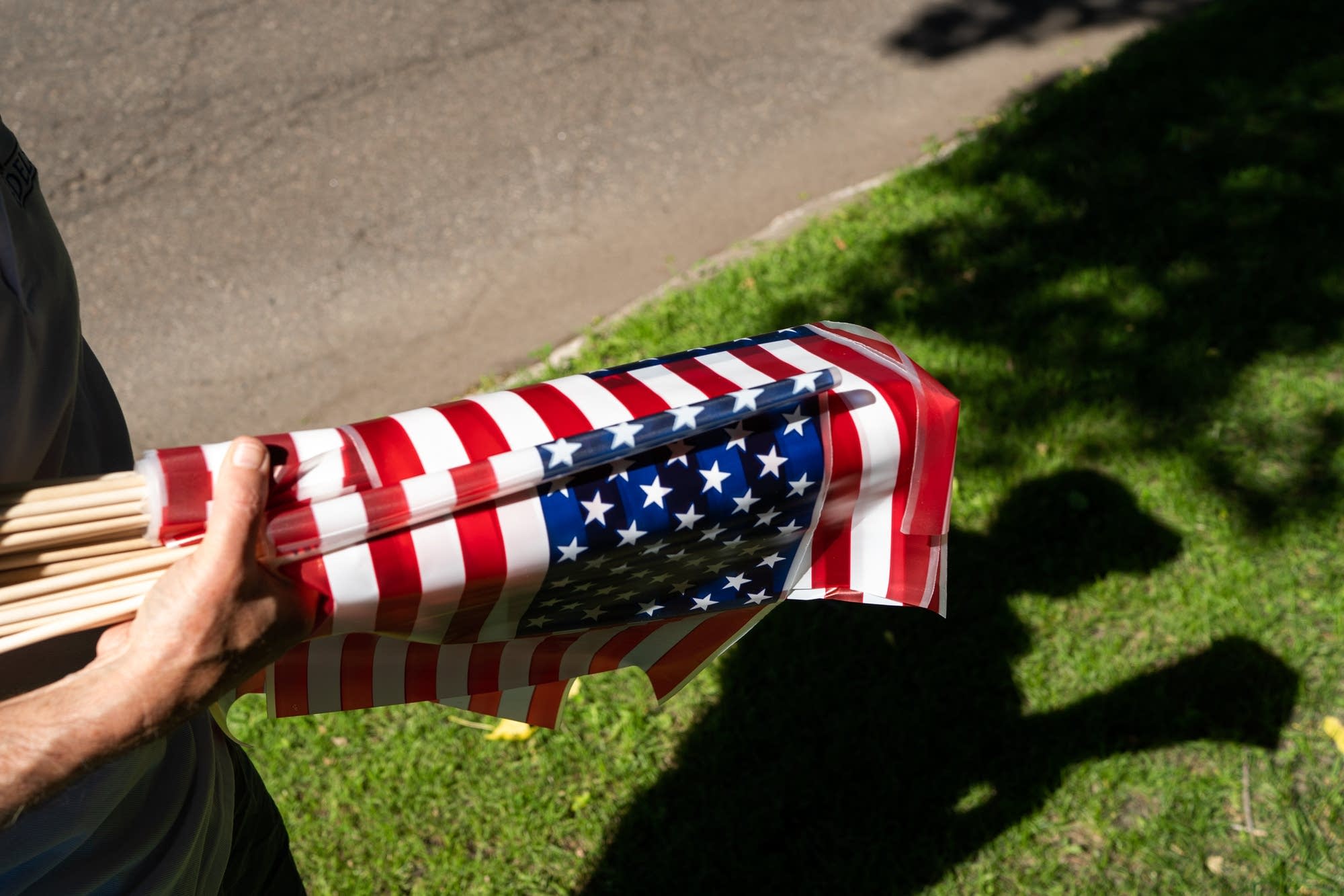 Tom Edelstein holds a bundle of American Flags.