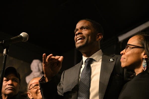 A man talks and raises his hand