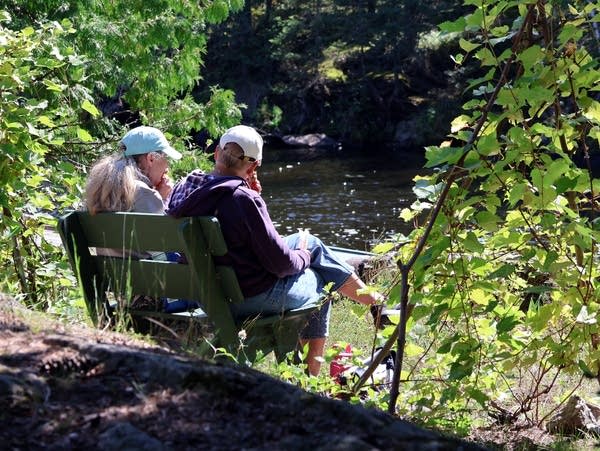two people seated on a park bench
