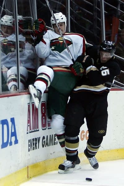 Kurtis Foster of the Minnesota Wild gets checked