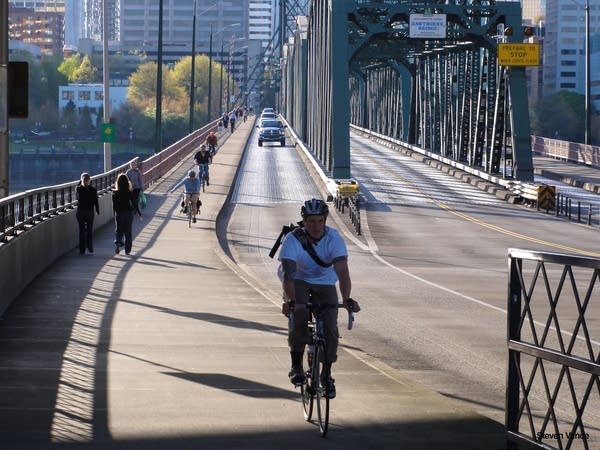 Cyclists and pedestrians share a sidewalk on a Portland bridge