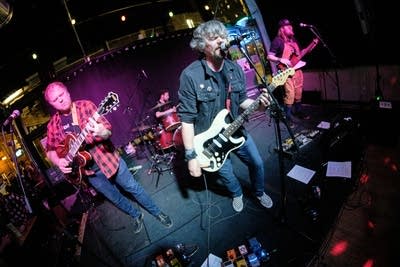 Four musicians performing onstage