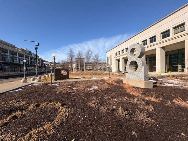 Wide shot of the plaza in front of a beige concrete building.