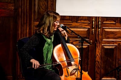 A musician plays cello in a pub 