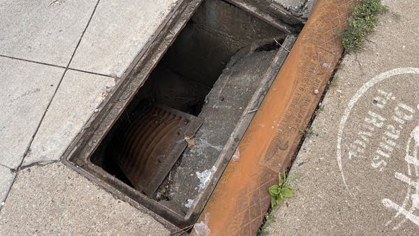Image of a storm drain with the cover grate broken off and lying inside the basin.