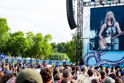 Sheryl Crow performing on stage and crowd watching