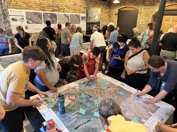 People gather around a table with a map