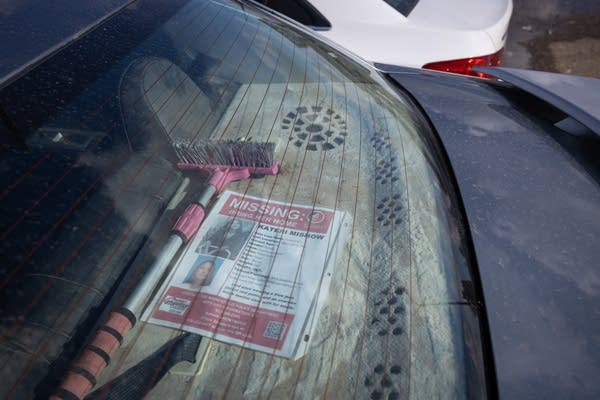 A missing poster sits in a car