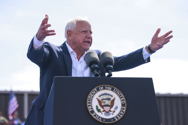 A man motions to the crowd with his hands