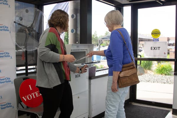 A voter deposits her ballot