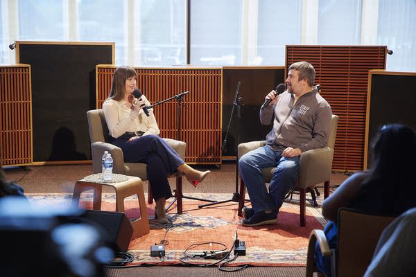 Two people have a conversation in a small auditorium