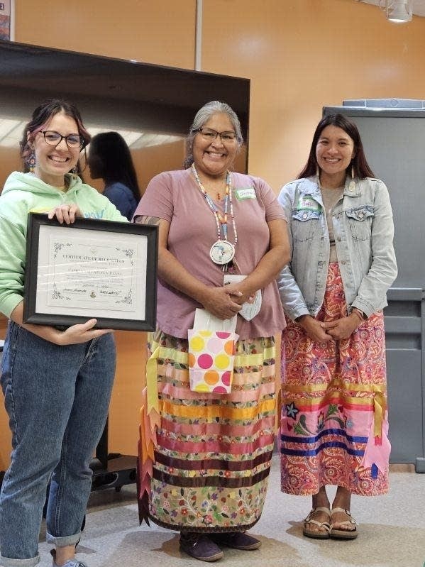 Three women stand for a photo 