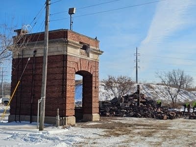 a brick structure stands next to a demolished one