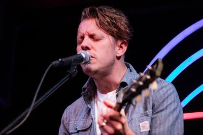Man playing electric guitar and singing on stage
