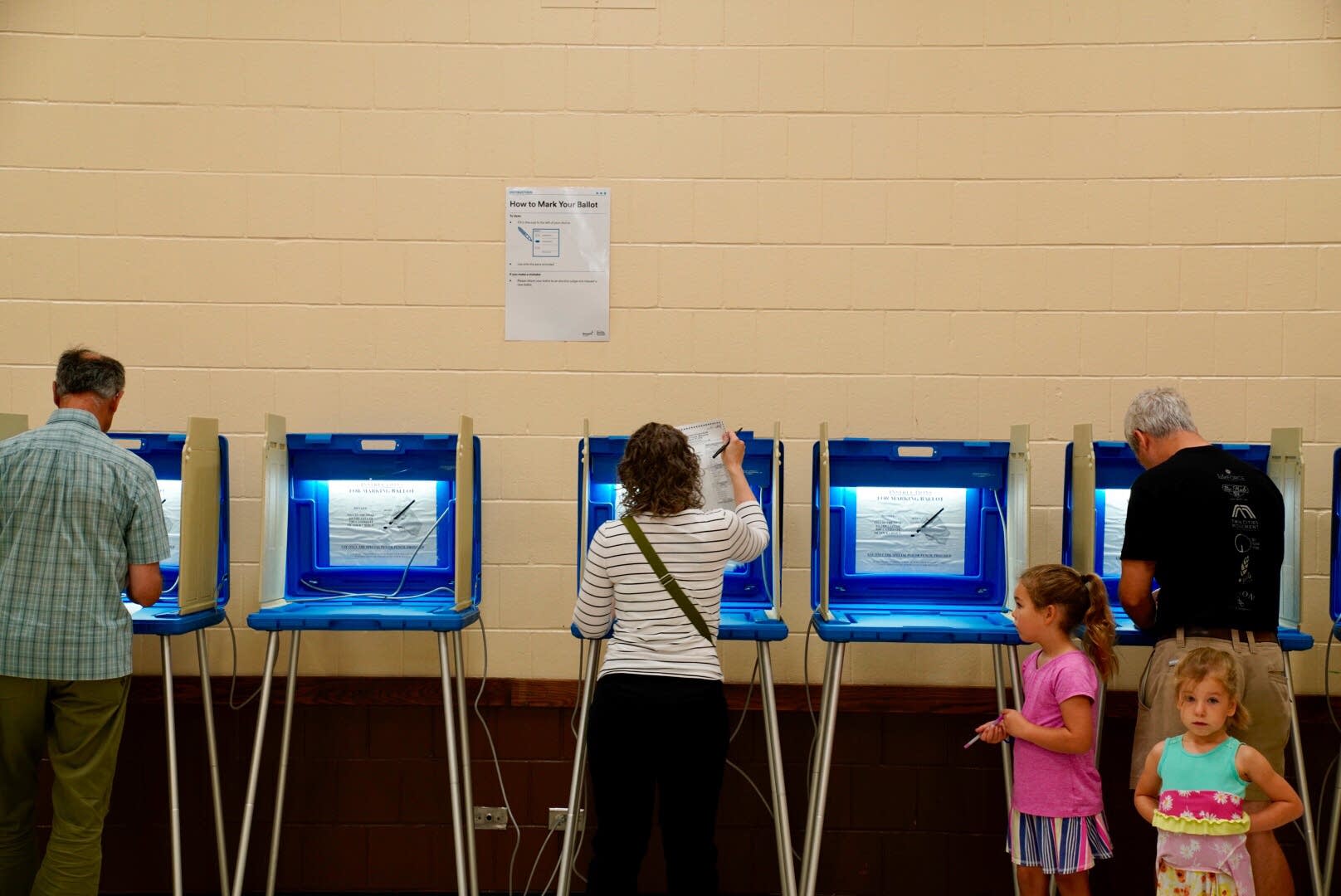 Justin Coyne, right, votes at the Pershing Park Recreation Center.