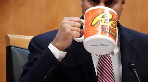 Federal Communications Commission Chairman Ajit Pai drinks from a big coffee cup during a commission meeting December 14, 2017 in Washington, DC. 