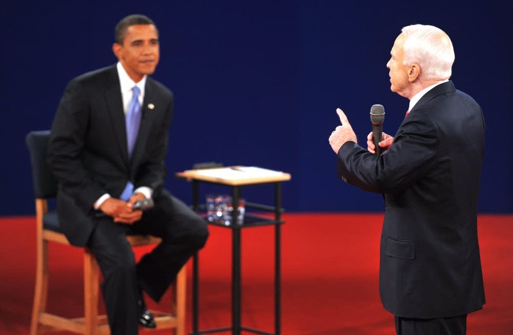 Sen. Barack Obama (L) listens to Sen. John McCain
