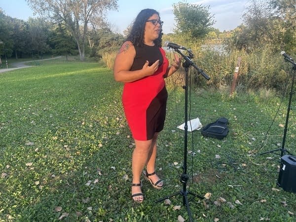 woman in red dress using microphone outside